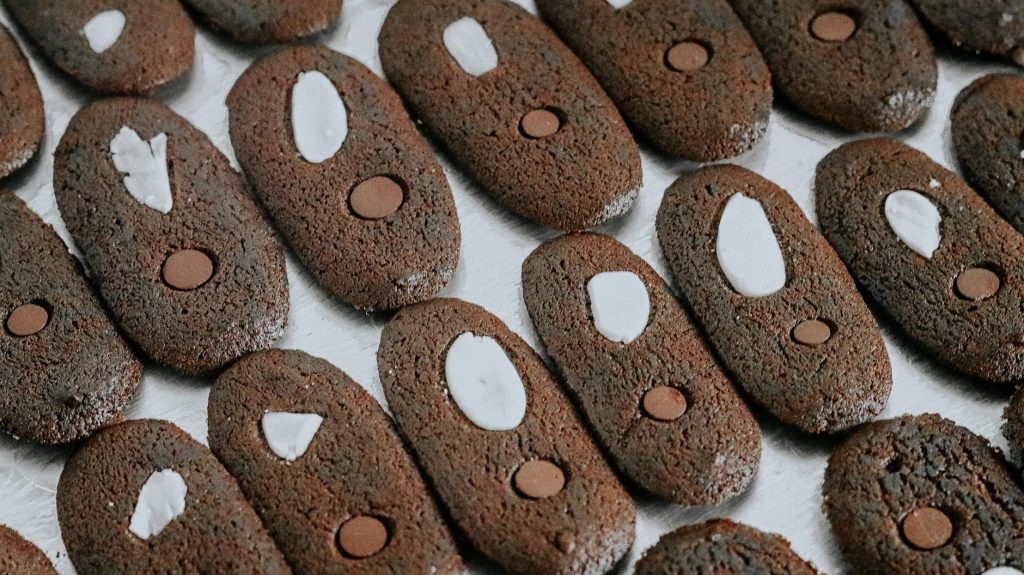 Close-up of chocolate cookies topped with almonds and chocolate chips, perfect for a sweet treat.