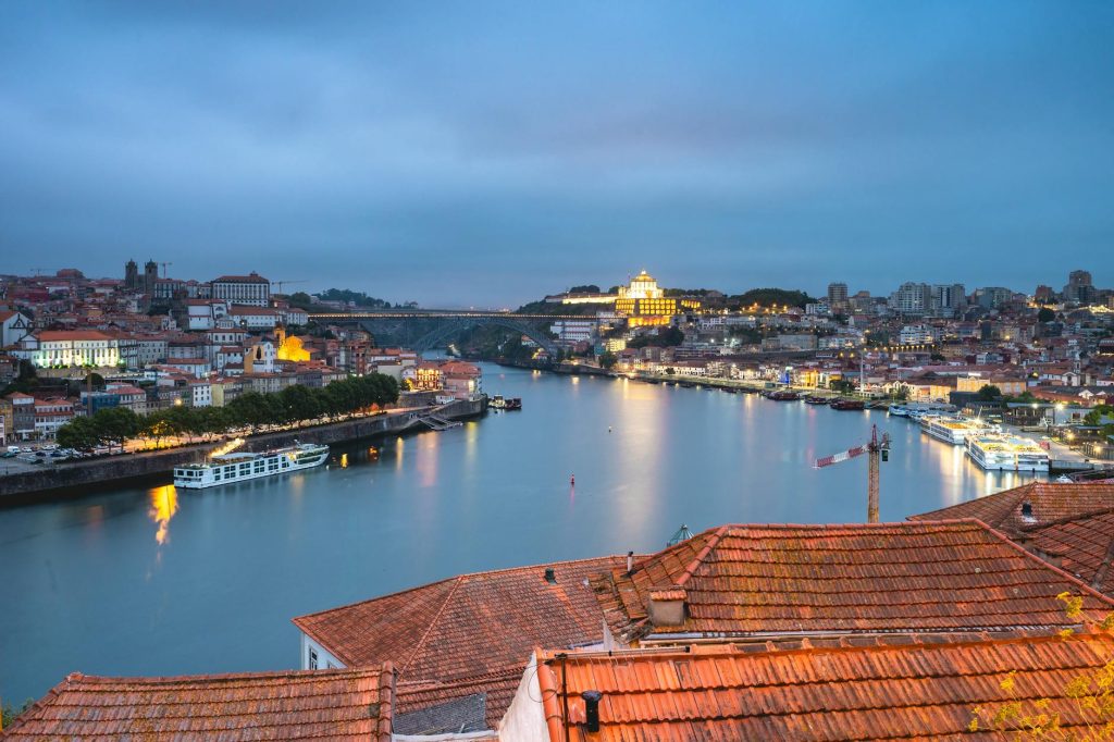 Stunning view of Porto cityscape and Douro River at twilight, highlighting Portugal's architectural beauty.