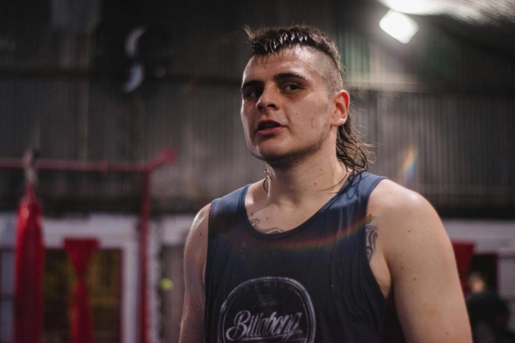 Focused portrait of a young athlete in a gym setting after intense training.