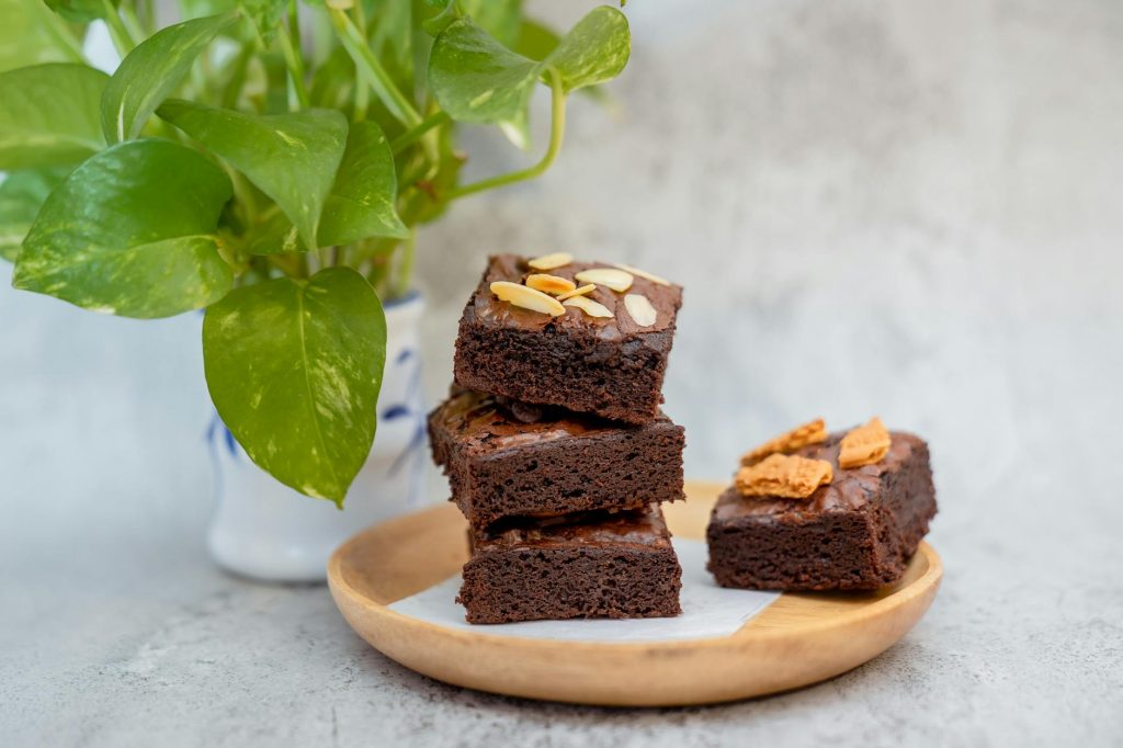 Stack of rich chocolate brownies with almond slices, perfect for dessert indulgence.