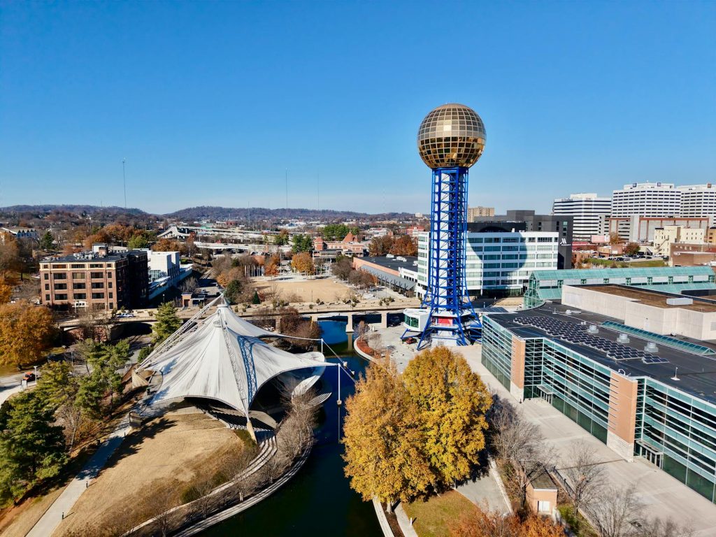 Drone view of the Sunsphere at World's Fair Park, Knoxville, showcasing modern architecture and fall foliage.