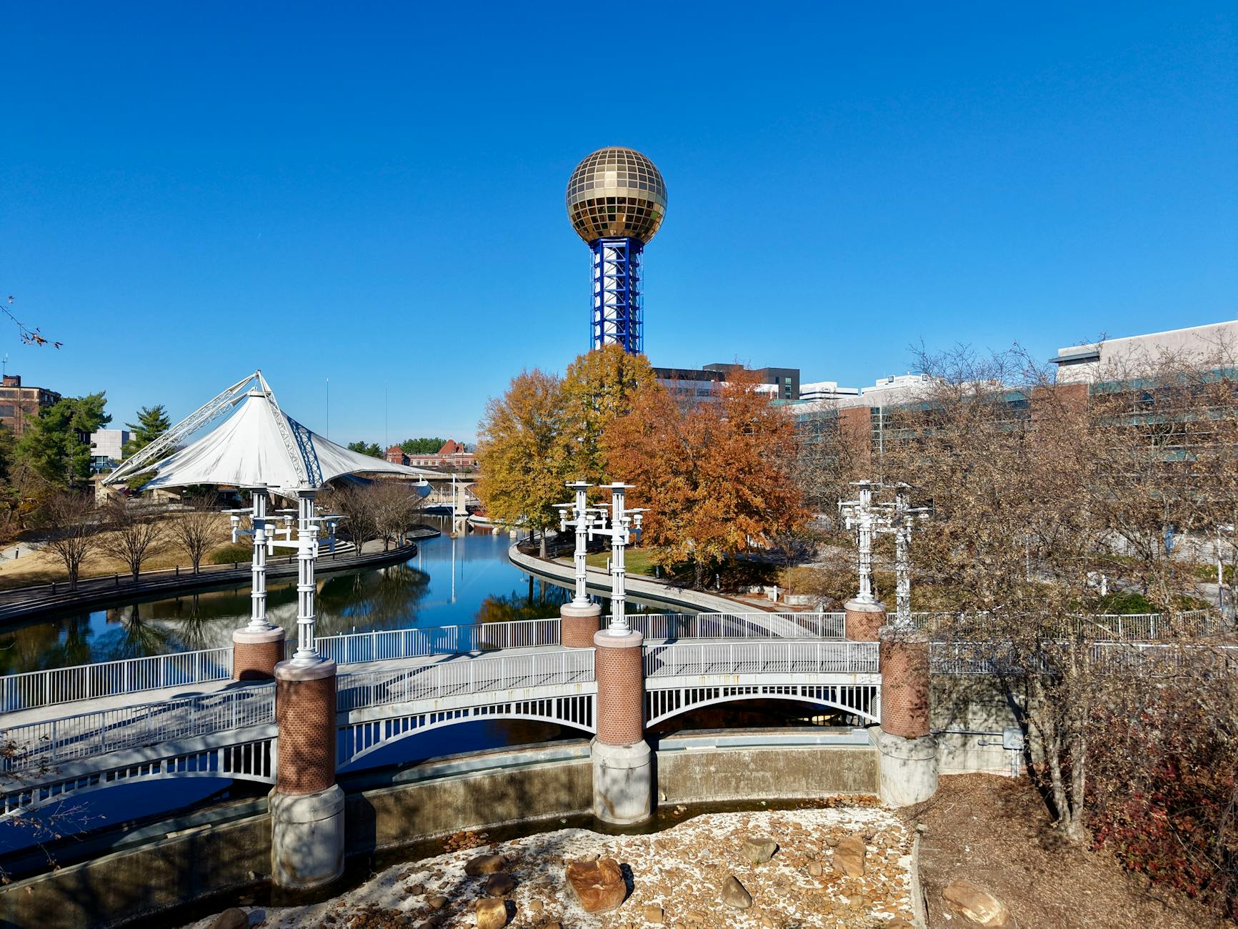 A vibrant aerial view of the iconic Sunsphere amidst fall foliage in Knoxville, Tennessee.