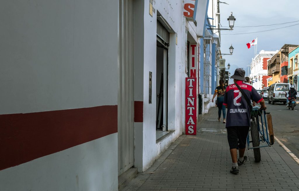 A street vendor pushing a cart in Trujillo, Perú, showcasing Peruvian urban life.