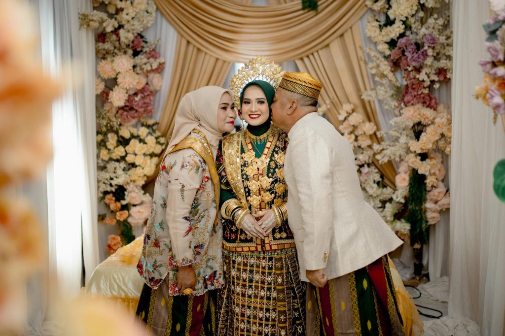 A joyful Bugis wedding with family in Kendari, showcasing vibrant traditional attire.
