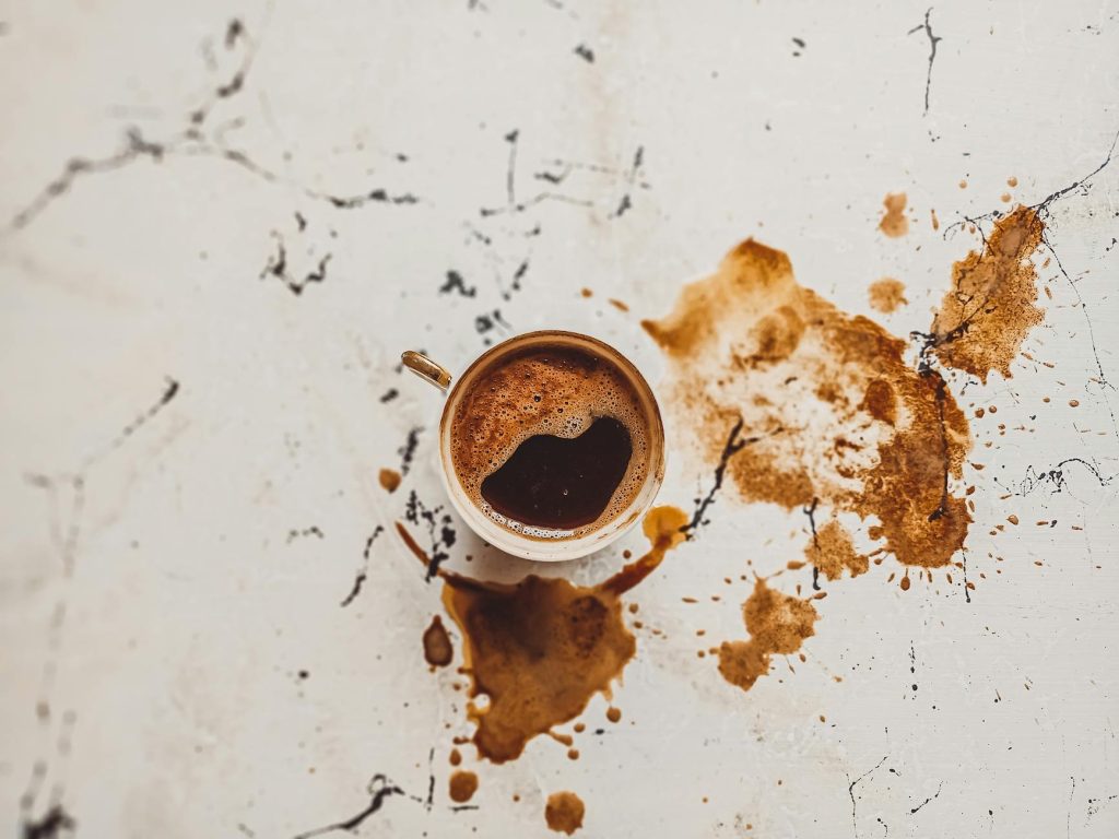 A top view of a Turkish coffee cup with spills on a marble surface, capturing the traditional beverage's essence.