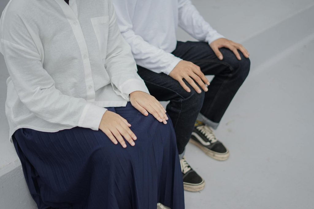 A couple in casual attire sitting on outdoor steps, showcasing togetherness.