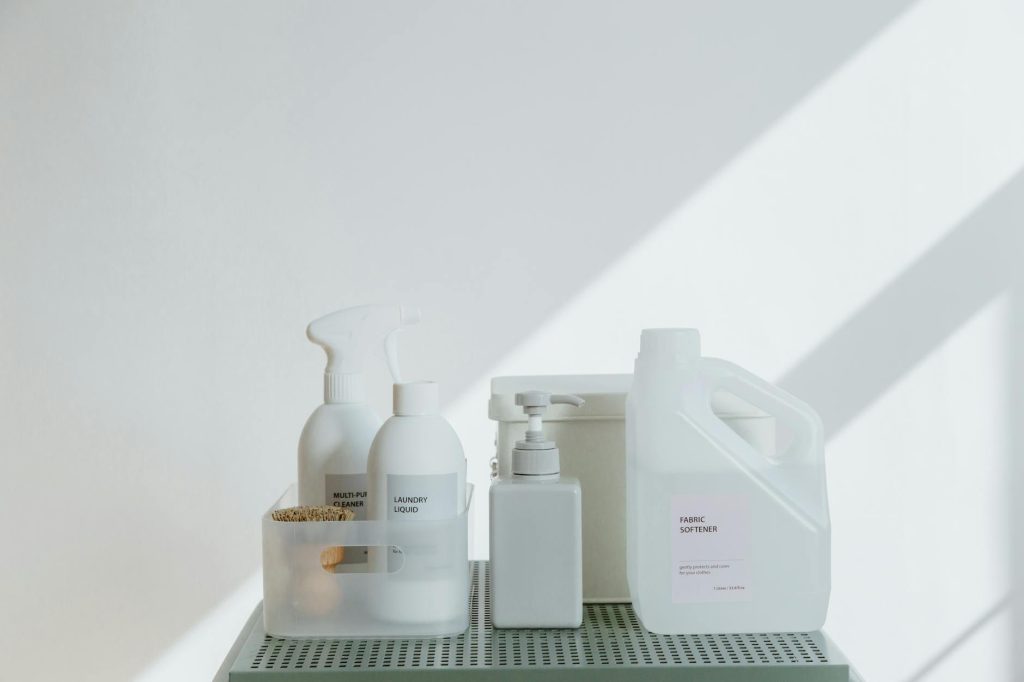 Clean and simple display of various cleaning products in soft lighting on a white background.